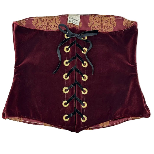 Maroon velvet corset with gold grommets with black ribbon laced up the back on a white background